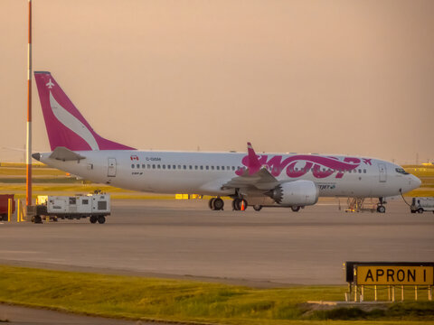 Calgary, Alberta, Canada. September 9, 2026. Swoop Boeing 737 MAX 8 aircraft parked at terminal gate during golden hour sunset.