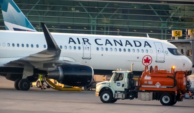 Calgary, Alberta, Canada. Sep 9, 2026. Air Canada passenger jet parked at gate 54 with ground service fuel truck on tarmac during service.
