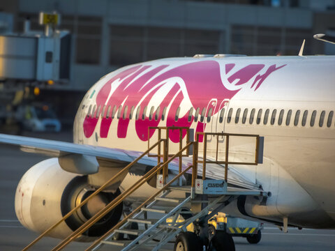 Calgary, Alberta, Canada. Sep 9, 2026. Close-up side view of Swoop airplane fuselage with boarding stairs parked at airport tarmac.