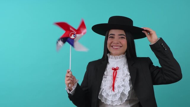 Cheerful young woman wearing a traditional huaso costume holding a spinning pinwheel
