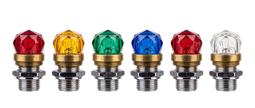 Faceted glass indicator light bulbs in a row, vintage industrial pilot lamps with colorful crystal dome covers and threaded metal bases over a black background for control panel concept design setups.