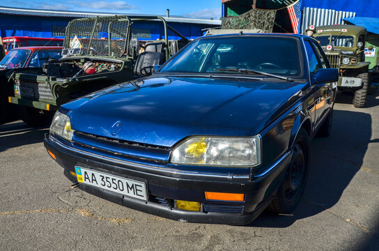 Dark blue Renault 25 showcases its aerodynamic 80s silhouette and signature yellow fog lights flagship liftback celebrated for classic French design and heritage