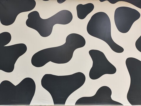Abstract black and white cow print spots pattern on a smooth surface