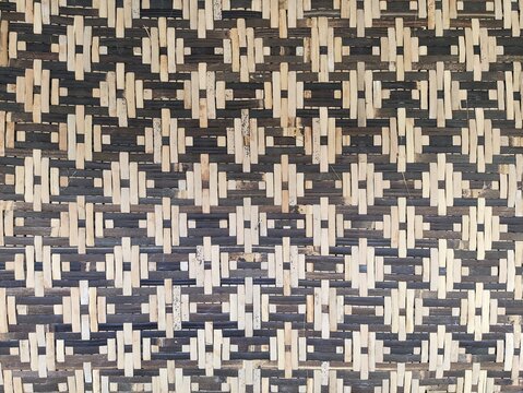 Traditional Indonesian woven bamboo wall panel texture with geometric diamond pattern