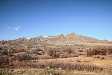 Snow-Dusted Mountains Rise Above Rural Town Outskirts, Nevada © jia