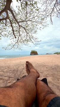 Man relaxing on a sandy beach with a beautiful seascape view