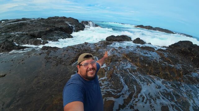 Influencer vlogging at a rocky beach with ocean waves crashing