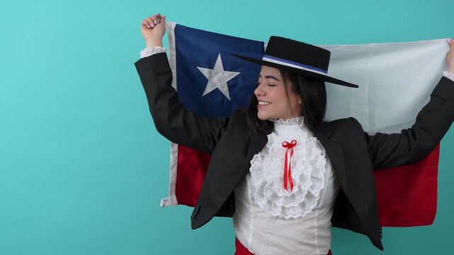 Happy young woman in traditional chilean clothes celebrating while holding the flag of chile