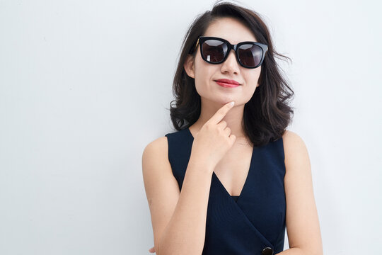 Stylish Asian woman wearing sunglasses on a white background