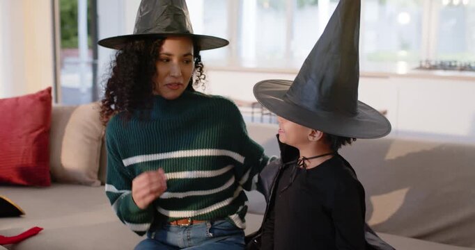 African American mother and daughter, mother talking hugging on sofa, soothing child in witch hat