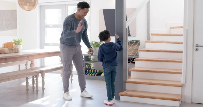 African American father in sweater offering toy rewarding child touching post at entry, high-fiving