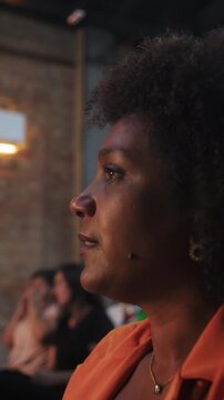 Attentive woman listening carefully to a speaker during an indoor event conveying deep focus, intellectual engagement, and thoughtful interest
