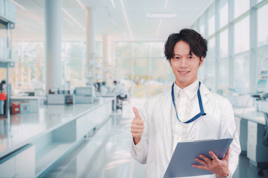 白衣を着て研究室で研究をする男性の研究員