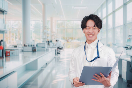 白衣を着て研究室で研究をする男性の研究員