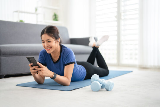 Fitness woman with earphones listening to music after workout.