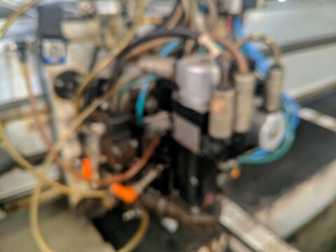 Close up blurred abstract view of industrial machine components and wiring in a factory setting