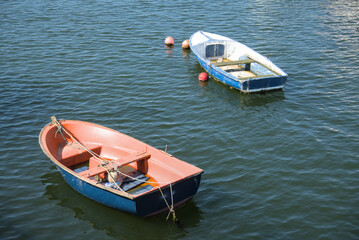 Two small wooden dinghies moored on the calm water of a fishing harbour © ekaterina_kutuzova