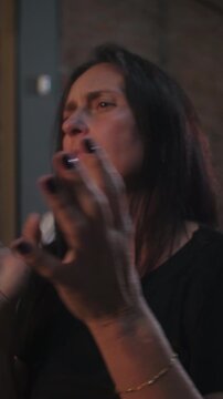 Woman enthusiastically applauding and shouting bravo during an indoor event conveying joyful celebration, genuine praise, and vibrant energy
