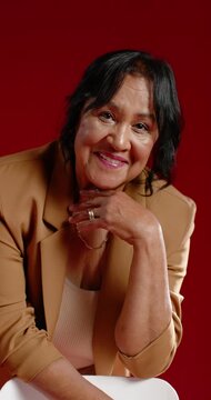 Vertical video: African American senior woman responding to camera cue, posing in studio