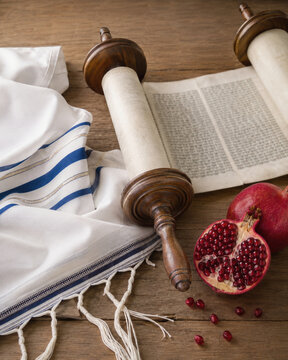 Jewish Religious Symbols: Torah Scroll, Tallit, and Pomegranates on Wooden Table