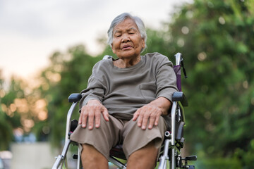 senior woman suffering from knee pain while sitting in wheelchair at park © geargodz