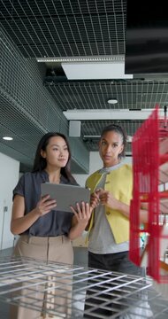 Two Women Architects Collaborating in Modern Office Space using Digital tablet