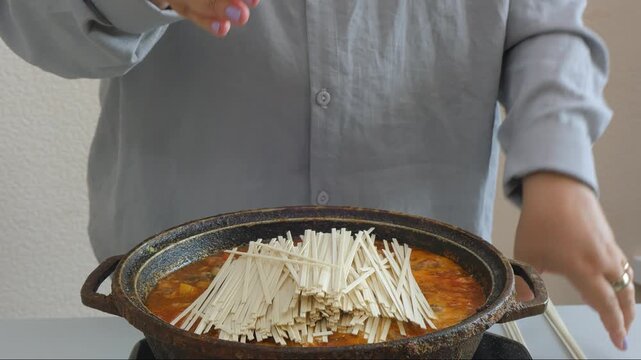 Vegetables and meat are stewed in a deep cast-iron skillet with sauce