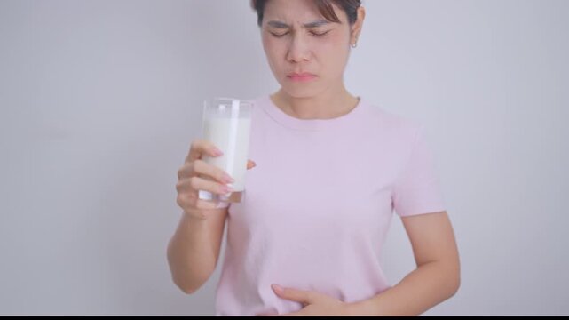 Lactose intolerance and Milk allergy concept. woman with Milk glass and having abdominal cramps and pain when drink Cow Milk. Symptom stomach ache, Dairy intolerant, Nausea, Bloating, Gas and Diarrhea