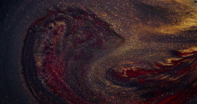 Ink spill. Sparkling fluid. Defocused yellow red colorful glitter mix acrylic texture floating on abstract creative art background.