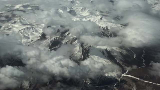 Stunning window seat view of massive snow-covered mountain ranges in Northwest China during a flight. 