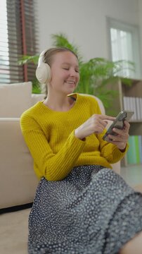 Happy young woman listening to music on smartphone