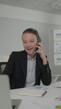 Businesswoman talking on the phone and writing in notebook