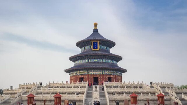 Temple of Heaven in Beijing, China, with tourists ascending the triple-tiered marble terrace under a partly cloudy sky
