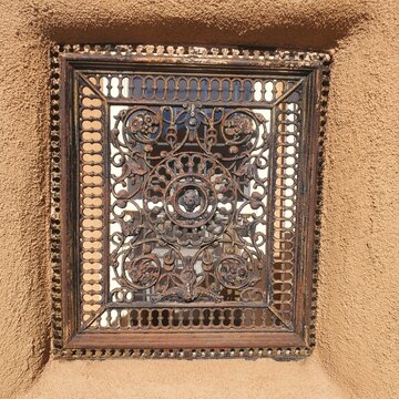 Detail of old iron grate in adobe wall