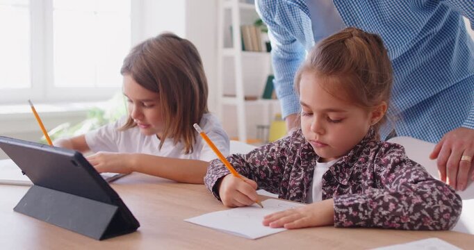 Small preschooler boy, girl, tutor teacher, father at desk study online on laptop, happy smart little kids learning using internet lessons on quarantine, homeschooling, preparing for school, testing