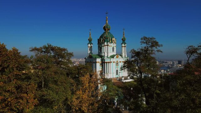 Drone view of Saint Andrew Church framed by autumn trees in Kyiv