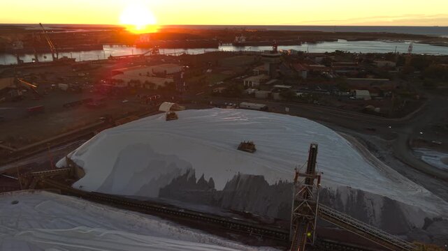 Excavators load raw material onto conveyors for shipping port hedland australia