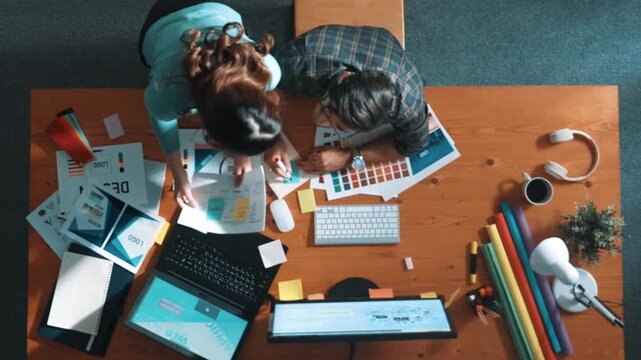 Top view of project manager looking at screen while designer writing idea. Close up of smart business team explain idea of logo design while designer choose theme while looking at palette. Symposium.