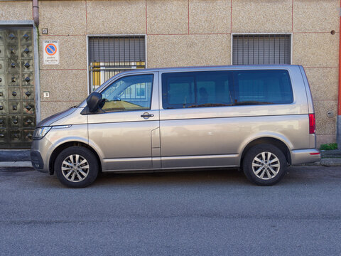 Silver Volkswagen Transporter T6 Multivan parked along a residential building, showcasing modern design and practicality for urban mobility and family adventures