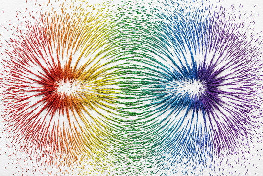 Colored iron filings visualizing a magnetic field, concept of science and invisible forces