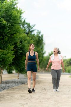 Asian senior mother and adult daughter exercise walking outdoor at  park.