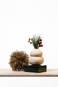 Elegant minimalist Christmas sale display featuring a white ceramic vase with pine and red berries on a dark green gift box. Perfect for modern holiday decor promotions and luxury retail banners.
