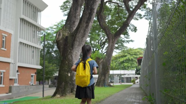 Young asian student girl walking to school in the morning