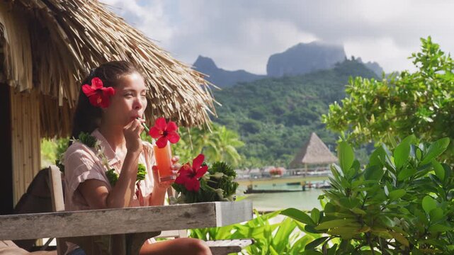 Breakfast at luxury on beach. Woman drinking fruit juice on summer vacation travel in Bora Bora island, Tahiti French Polynesia. Raw video of real unretouched woman model without any makeup