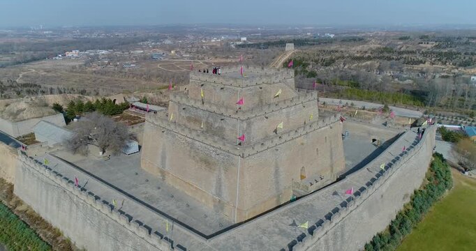 Aerial drone view of Zhenbei Tower in Yulin, ancient Ming Dynasty fortress with visitors on ramparts and surrounding walled complex