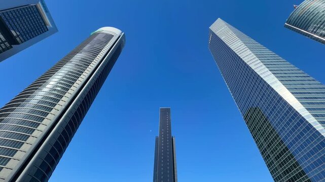 Modern skyscrapers of the Cuatro Torres Business Area in Madrid, Spain, rising towards a clear blue sky, showing the contemporary architecture and financial district of the spanish capital city