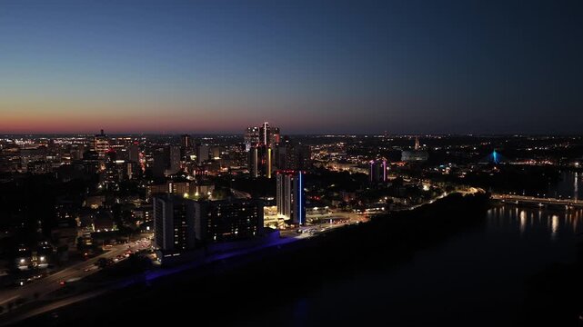 Night shot of Winnipeg, MB with Main Street, Esplanade Riel, Museum of Human Rights and Red River visible, 4K drone clip.