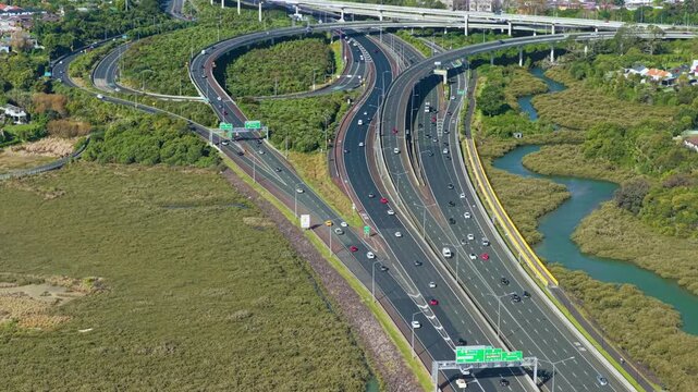 Aerial view of traffic flowing on the Pt Chev highway interchange surrounded by wetlands in Waterview, Auckland, New Zealand.