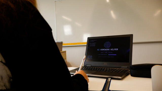 Student in a school classroom actively engaging with an artificial intelligence homework helper application on a laptop screen, leveraging digital tools for modern education and learning