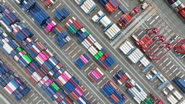 Aerial drone footage of a container yard from directly above, related to logistics, supply chain management, industry, shipping, cities, and society.